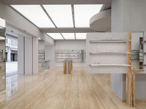 現代眼鏡店室內，拋光大理石地板與展示眼鏡的陳列架。