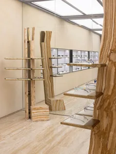 A modern retail space featuring wooden shelves and display cases filled with eyeglasses.