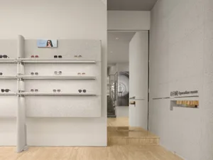 Modern storefront with concrete shelves displaying sunglasses.