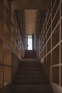 A wooden staircase with an illuminated ceiling and wall panels.