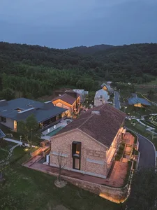 A modern building constructed with brick, surrounded by greenery and trees.