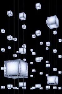 Modern lighting design featuring illuminated cubes hanging from black wires.