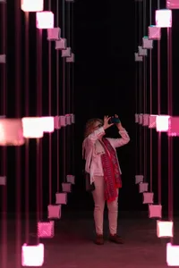 A woman takes a photo in an interactive light installation.
