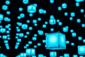 Minimalist blue glass cubes hanging on black background, suspended from ropes.