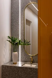 Modern minimalist bathroom with a terrazzo countertop and a sleek, white sink.