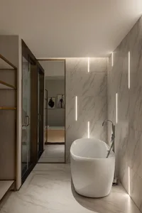 Spacious, modern-style bathroom with a freestanding bathtub, marble walls, and floor, featuring sleek, minimalist design elem