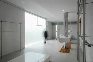 A modern minimalist office space featuring glass and metal elements.