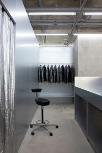 Modern minimalist wardrobe featuring a black stool and a counter.
