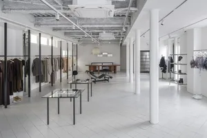 A modern retail store with white tiled flooring, minimalist design, and glass display cases.