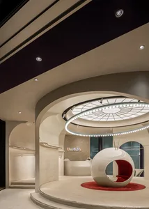 Modern retail storefront with a glass facade and a futuristic, spherical seating area inside.