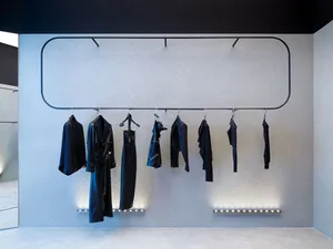 A sophisticated clothing display featuring black garments on metal racks in a retail interior setting.