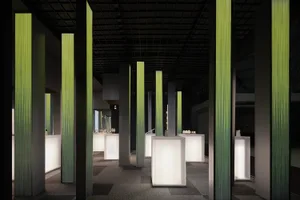 An interior exhibition space featuring modern LED columns and carpeting.