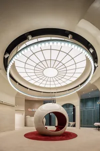 A modern interior design featuring a glass spherical structure on a red carpet.