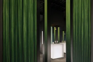 Modern interior design featuring green textured curtains at a minimalist bar counter.
