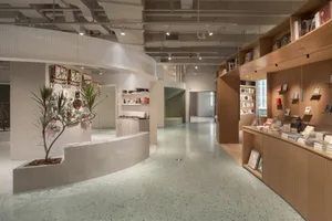 Minimalist bookstore interior with terrazzo flooring and wooden shelves.