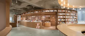 A minimalistic bookstore interior with wooden shelves and displays.