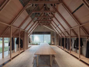 Modern interior space with minimalist design, featuring wooden materials and geometric wooden structure.