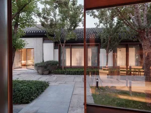 現代住宅空間，混凝土牆面搭配大型玻璃窗。