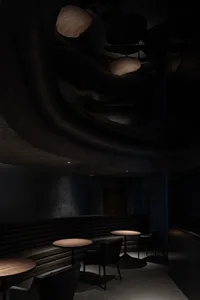A modern restaurant interior featuring leather seating and wooden tables.