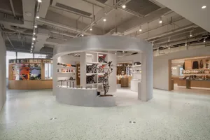 Modern retail boutique showcasing sleek design with concrete flooring and white wall displays.