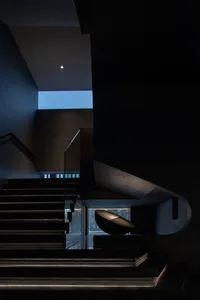 A modern staircase constructed from black concrete.