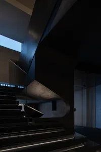 Modern concrete staircase with a glass railing.