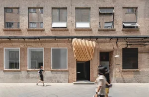 Brick facade with metallic accents and geometric patterns in an urban setting.