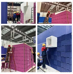 Workers assembling a large-scale art installation using red and blue foam pins on a construction site.