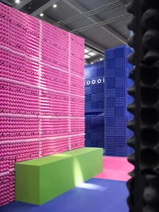 A minimalist installation featuring artist-made polystyrene columns in a vibrant pink and blue color palette.