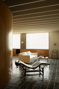 Modern minimalist living room featuring a concrete floor and white furniture.