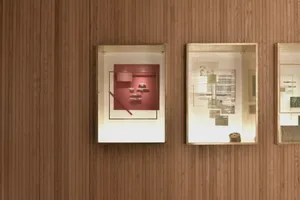 Glass-enclosed exhibit cases displaying various art pieces.