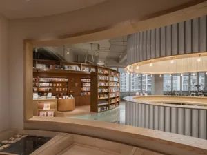 現代書店室內，配有圓形木質書架、玻璃牆面，以及圓形櫃檯。