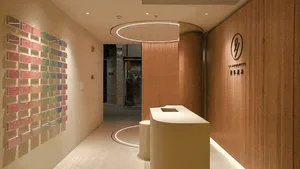 Modern interior design featuring a brick wall, wooden reception desk, and concrete floor.