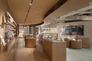 A modern bookstore with wooden shelves and display areas.