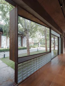 A modern lobby featuring glazed blocks on the wall, with a mix of metal, wood, and glass elements.