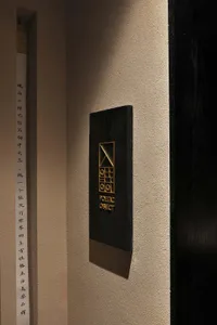 A 3D rendered metallic signage design on a textured beige wall.