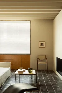 A minimalist living room featuring wood and glass elements.