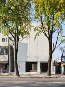 A modern retail storefront featuring a white-painted concrete exterior.