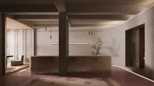 A modern, minimalist lobby with concrete walls and floor, featuring a reception desk and a single plant.