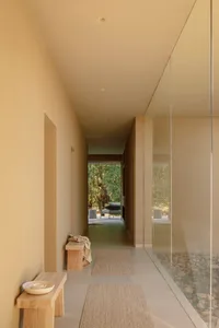 A minimalist residential interior featuring glass and steel materials.