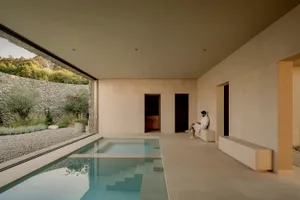 Minimalist spa interior with concrete, natural stone, and glass