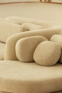 Close-up of a modern, brown fabric sofa with cushioned, rounded components.