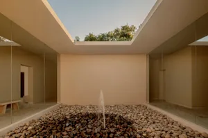 A modern residential interior featuring stone flooring and concrete walls.