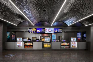 Interior design of a cinema concession stand with metallic texture and concrete materials.