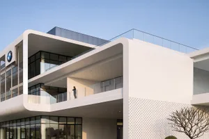 Modern BMW car dealership building with a white concrete facade and glass windows.