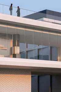 A modern balcony with large glass panels and concrete elements.