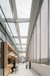 Modern corridor with glass walls, wooden counter, and metal railings