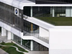Modern office building with glass walls and metal accents, featuring concrete elements
