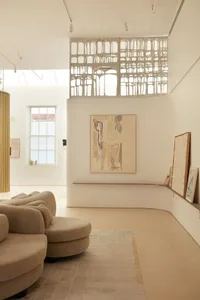 Modern living room with neutral-colored furniture and minimalist artwork.