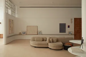 A minimalist living room with neutral-toned furniture and wall decor.